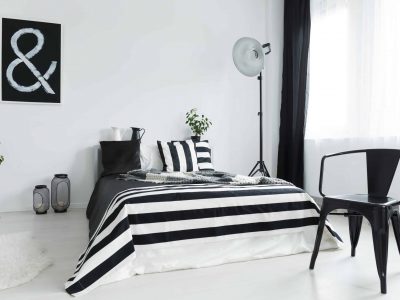 Stylish, black and white bedroom with black, designer chair