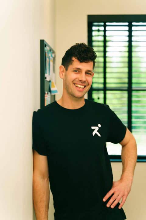 Een profielfoto van Matthias Byns, zaakvoerder van Revact, in de inkomhal van zijn praktijk.