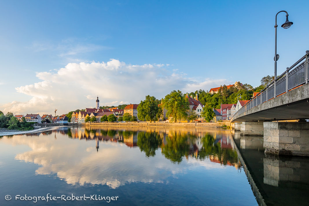 Die Altstadt von Landsberg spiegelt sich neben der Karolinenbrücke im Lech