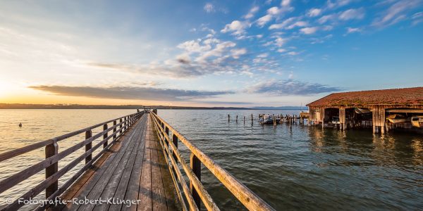 Ein Bootshaus und der Dampfersteg in Schondorf am Ammersee