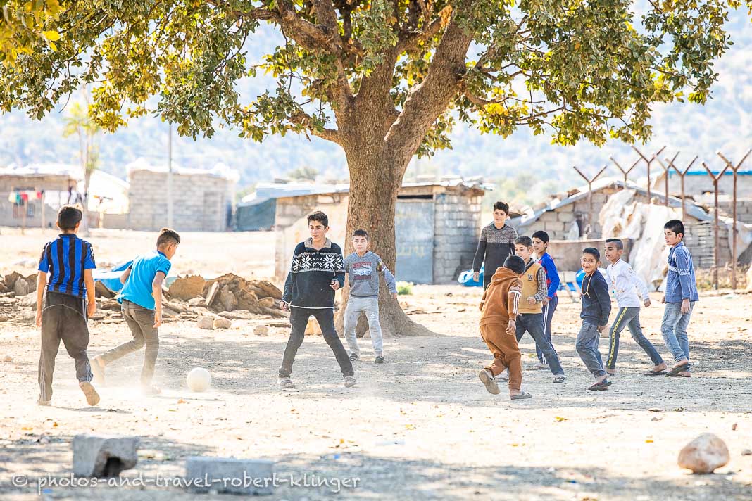 Buben / Jungs spielen in einem Dorf im Irak Fußball