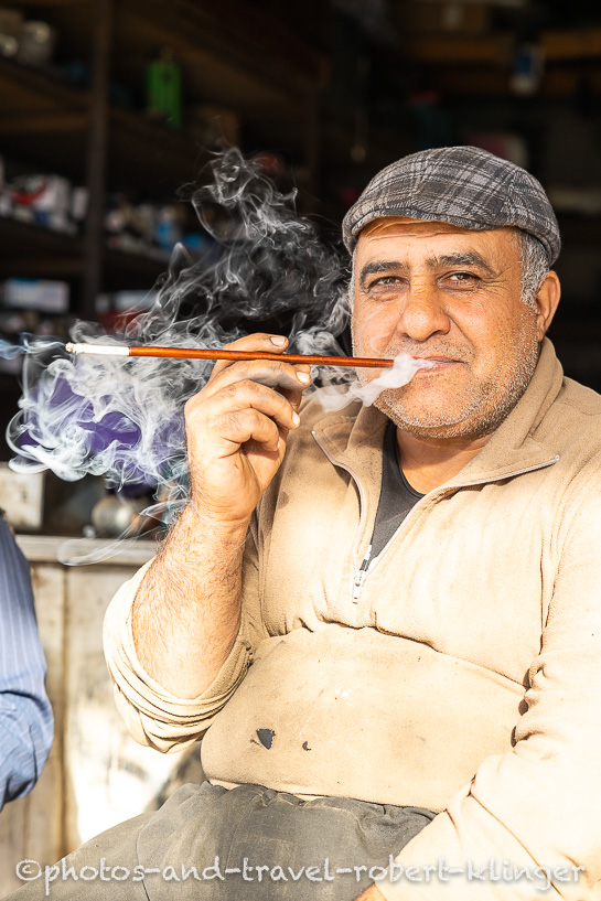 Ein kurdischer Automechaniker raucht eine Zigarette im Irak