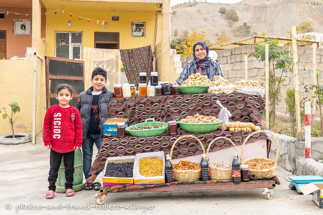 Eine kurdische Mutter verkauft mit ihren beiden Kindern vor ihrem Haus in Kurdistan im Nordirak