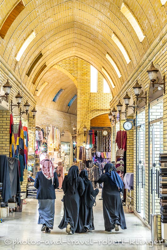 Ein arabischer Mann mit seinen drei Frauen auf dem Basar in Erbil im Irak