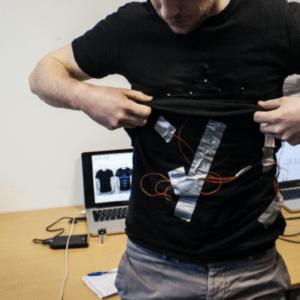Arduino workshops; a student putting on an interactive prototype that is attached to his shirt