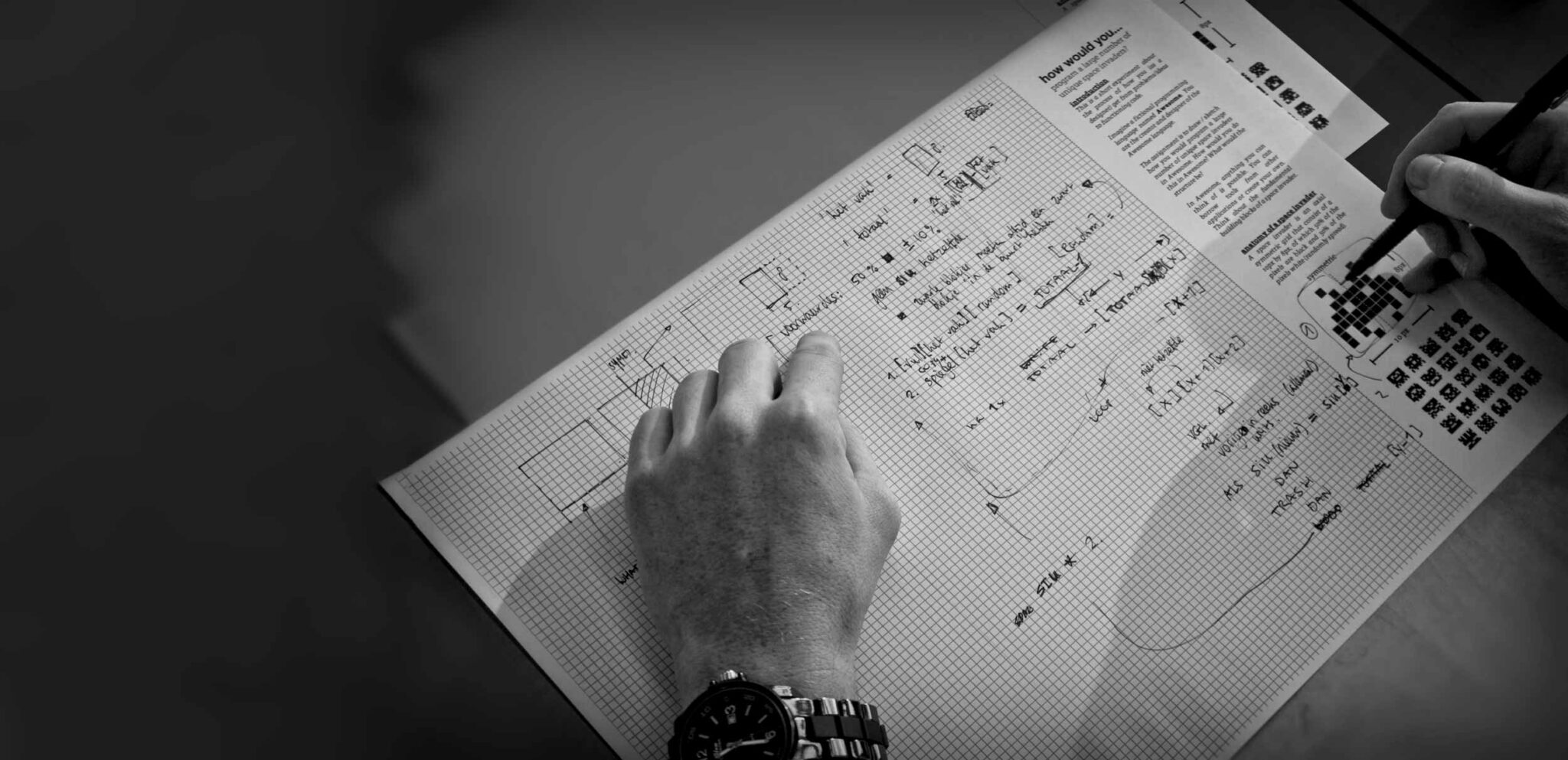 A photo of a person doing a paper programming exercise. The paper is full of notes and sketches.