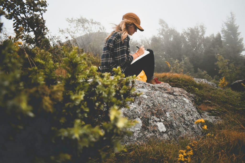 Reconnect through nature. Woman journaling.