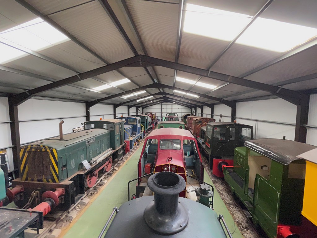 Three rows of locomotives inside the exhibition centre.