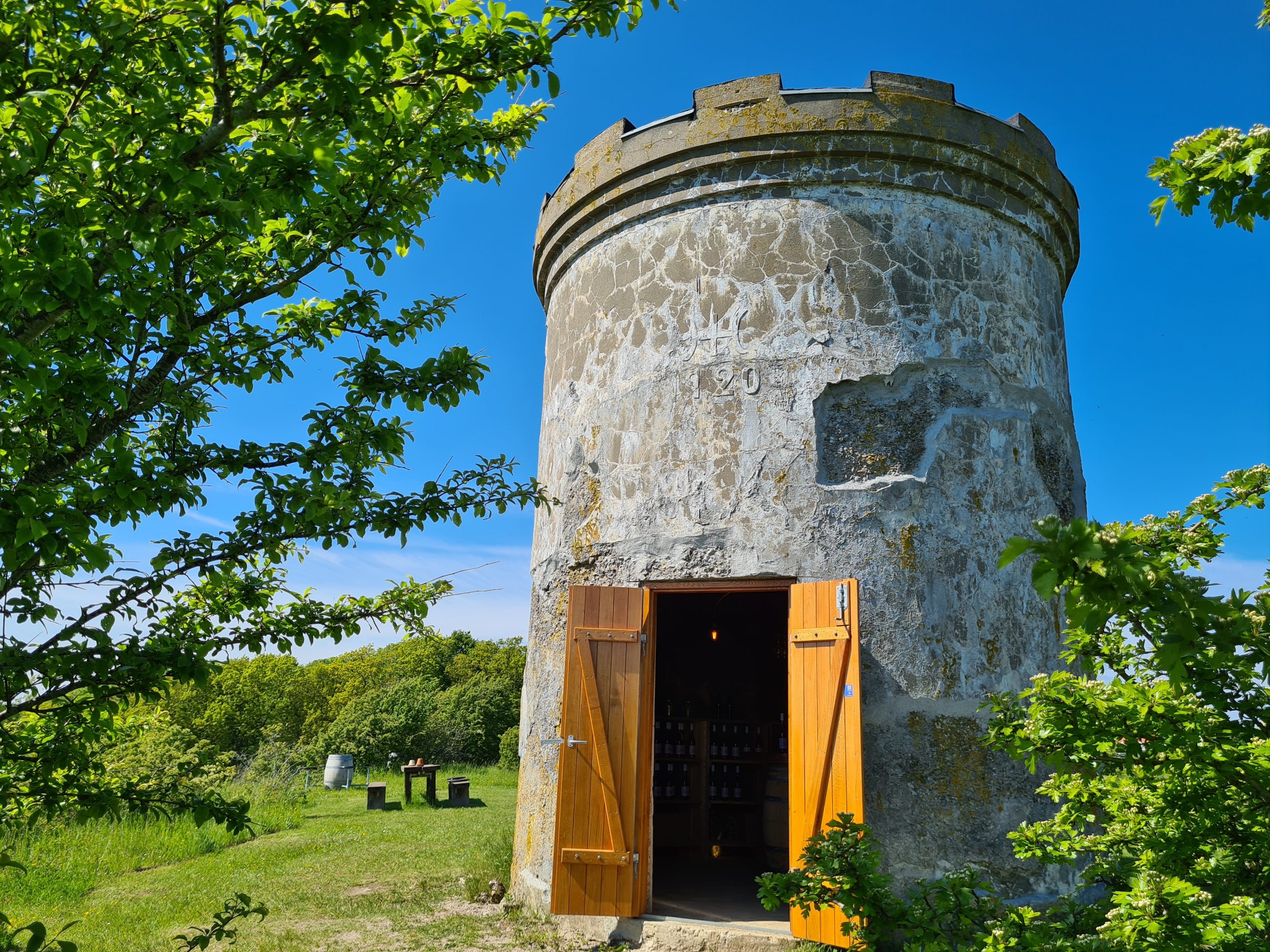 An old water tower on Røsnæs. The weather is nice, blue sky and green trees.