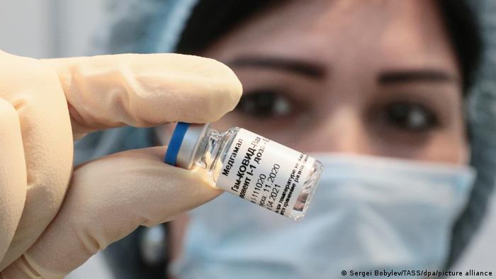 A female medical worker holding an ampoule with the Sputnik V vaccine