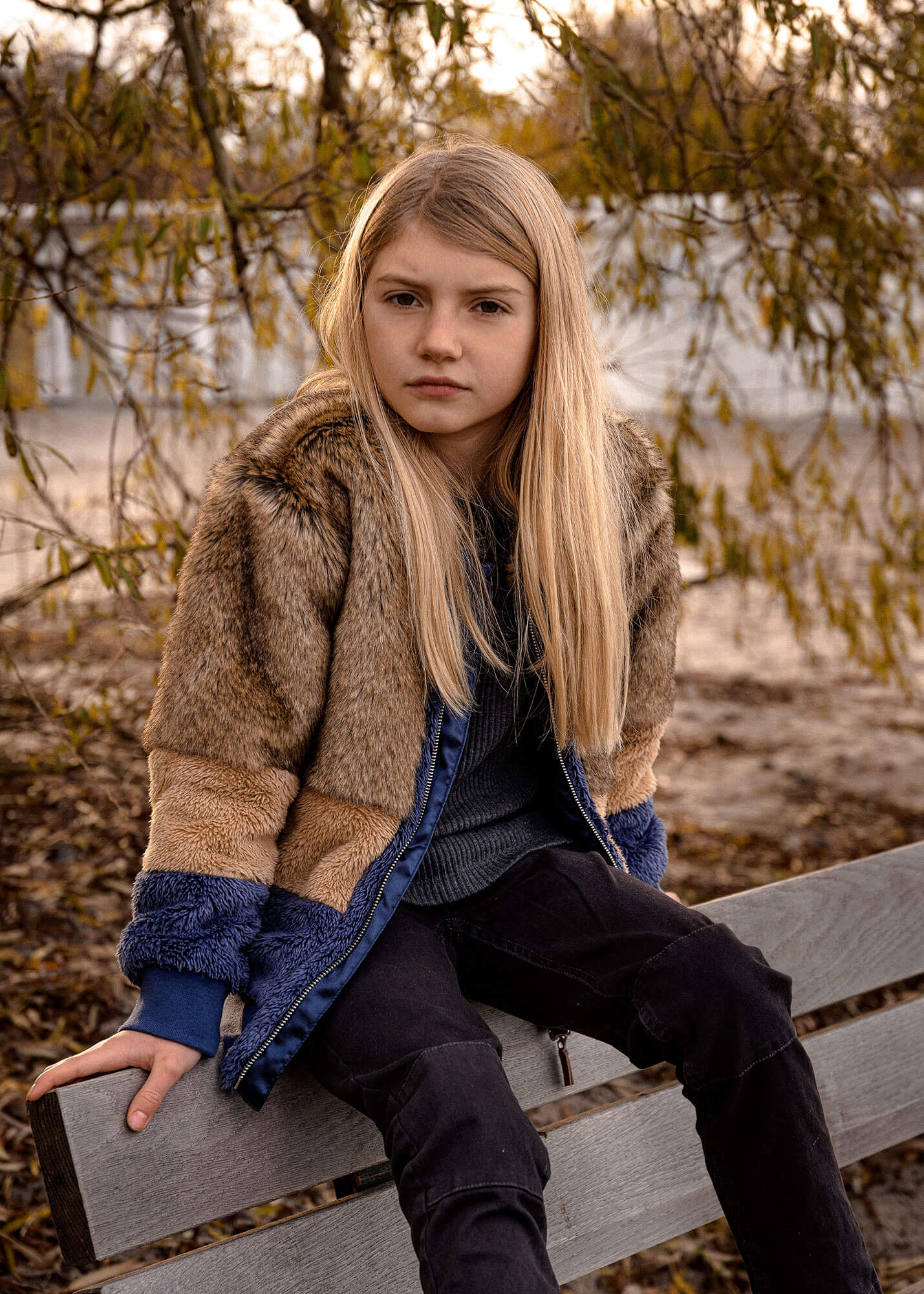 Kid posing on a bench, autumn dressed