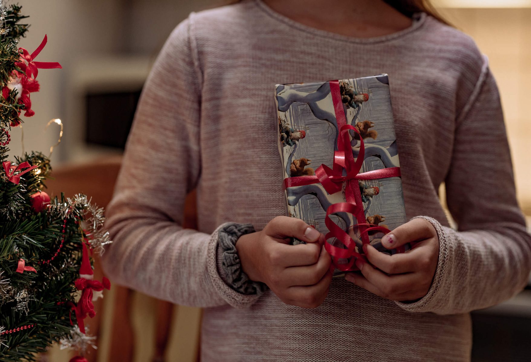 Kid holding a Christmas gift.