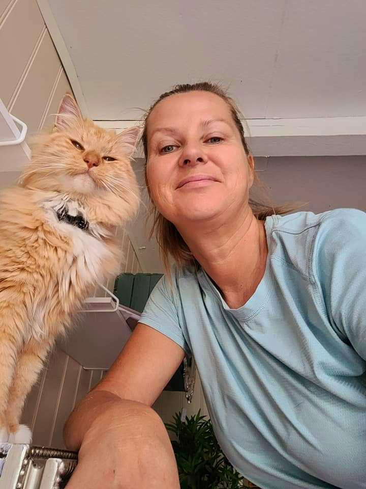 en dame og en kattt som smiler mot kamera