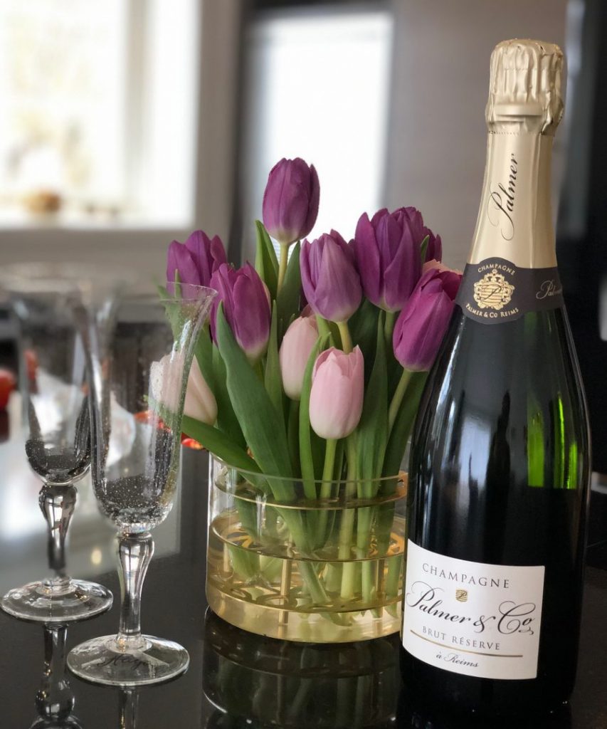 Champagneflaska glas och blommor på releaseparty