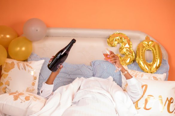 woman lying down in bed with champagne