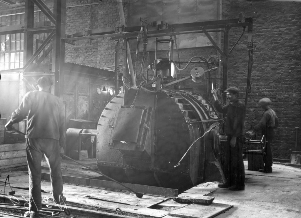 Bild på Avesta Jernverks första elektriska ugn, "Hönan". Herrar Magnusson, Lindén och Wiksell i arbete. Foto från 1927.