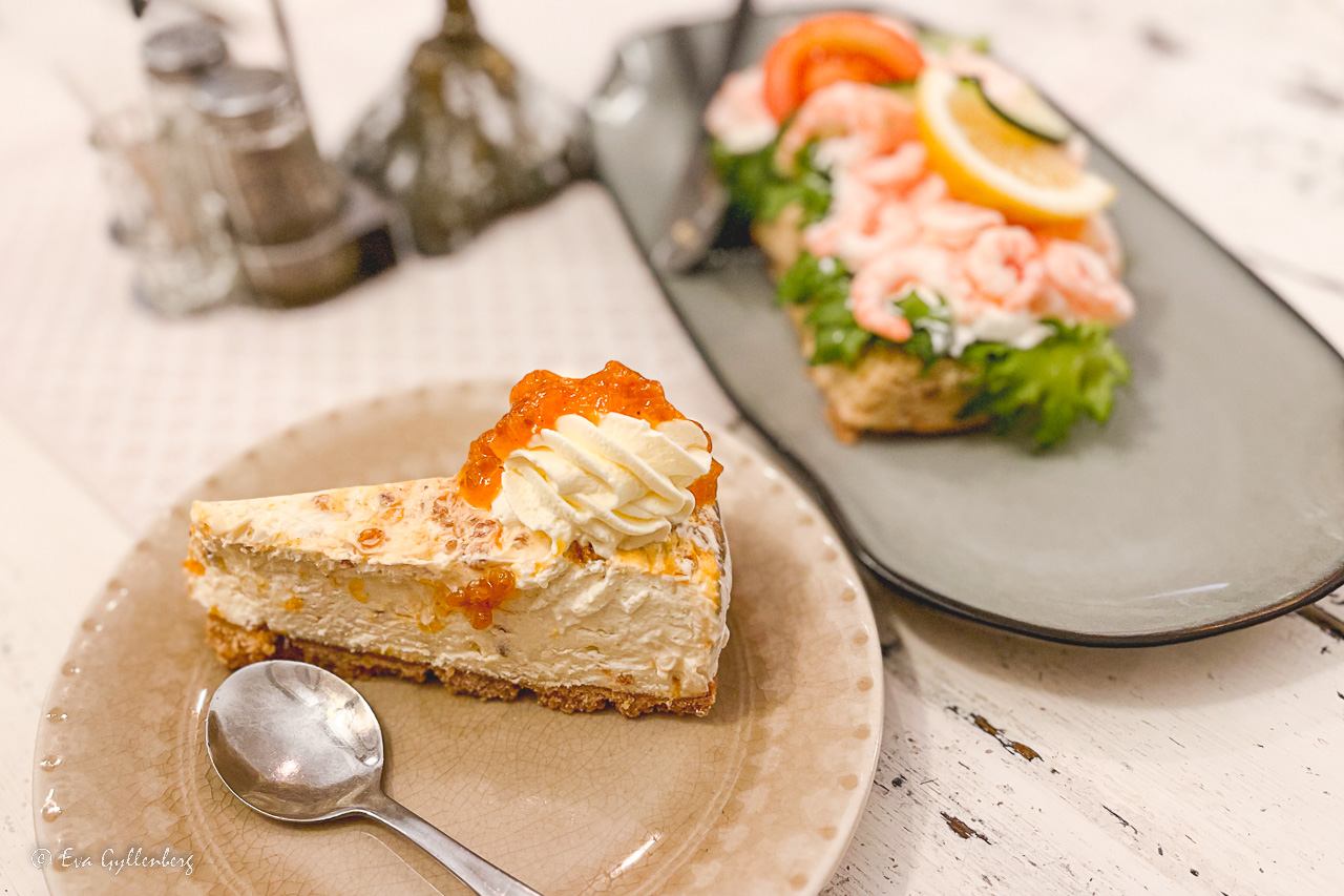 Raspberry cheesecake on a plate and shrimp sandwich on a plate - one of all cafes outside of Stockholm