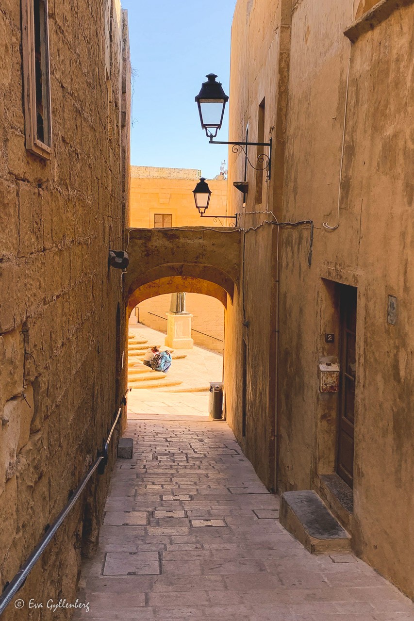 An alley with sandstone colored houses