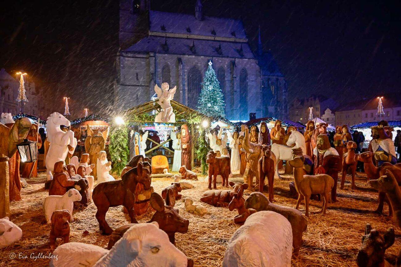 En stor julkrubba i trä en snöig vinterkväll