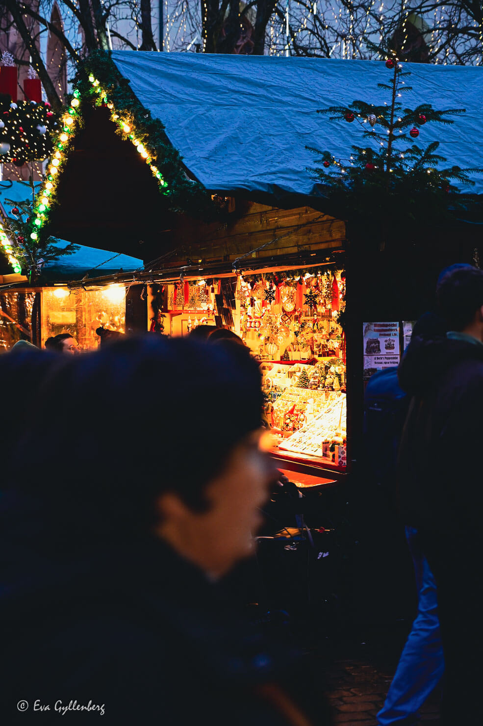 Människor passerar förbi ett julmarknadsstånd