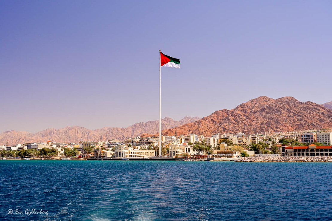 Den stora jordanska flaggan vid havet i Aqaba