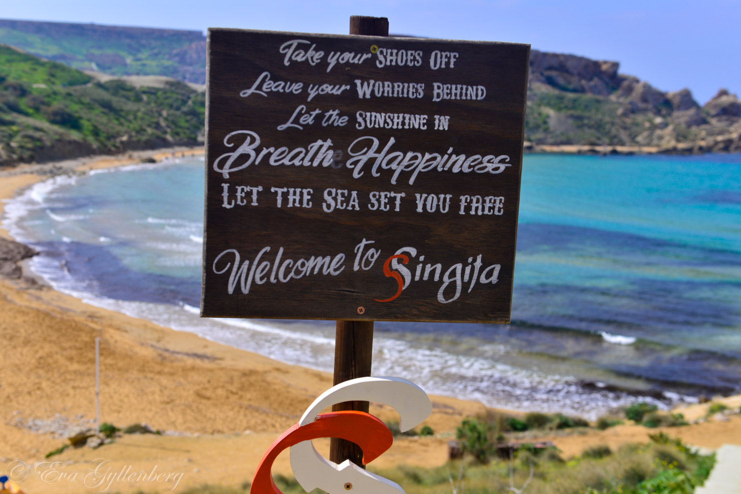 Għajn Tuffieħa beach with a sign welcoming you to Singita