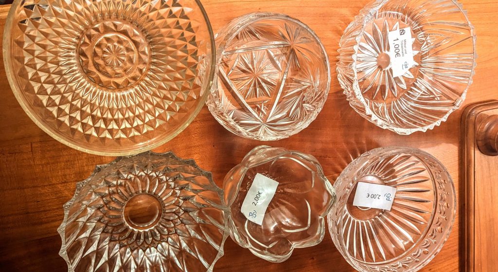 Six vintage glass bowls standing on a wooden surface.