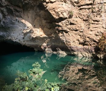 Glasklares Wasser im See der Altinbesik-Höhle mit Spiegelungen der Felsen.