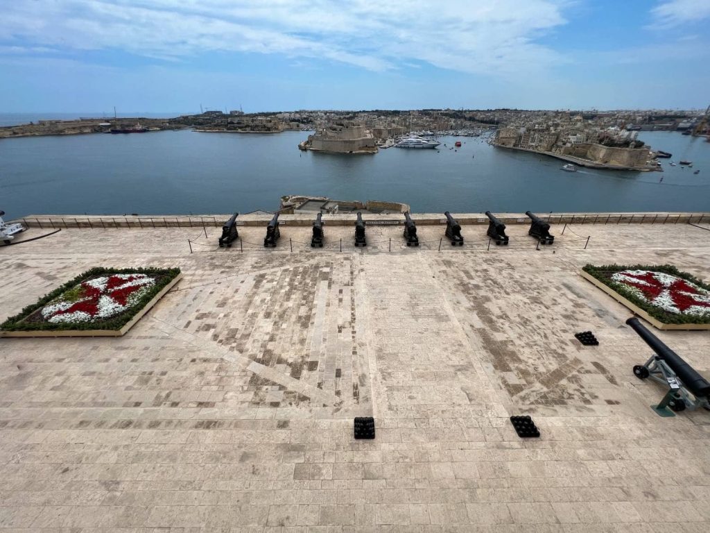 Blick in den Hafen Vallettas über die Kanonen von den den Upper Barrakka Gardens aus in Maltas Hauptstadt Valletta