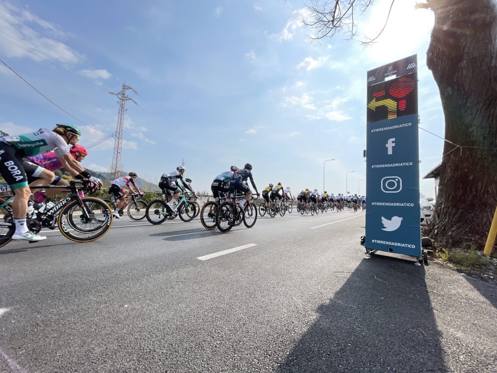 Tirreno-Adriatico 2022 using Safe Cycling Safety Sign (Mobile LED-sign for sporting events) with commercial space for event sponsors.