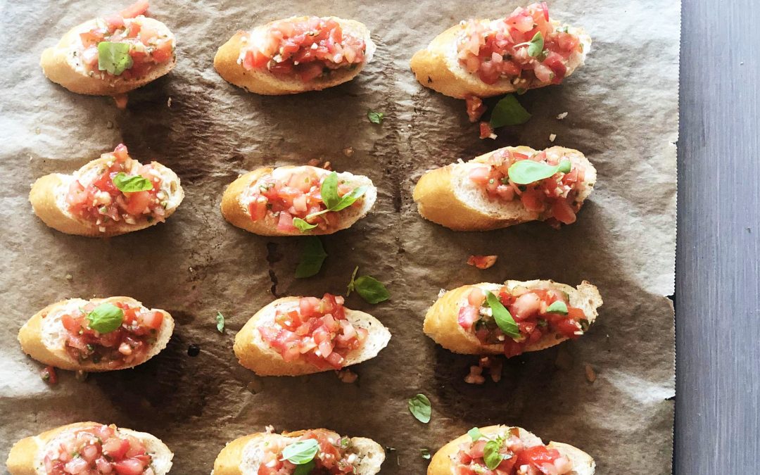 Italienske bruschetta på hvitløksbaguette med hakkede tomater, hvitløk og basilikum