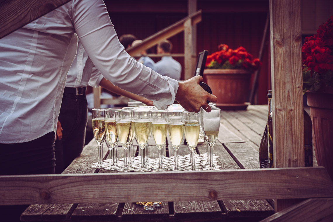 häller upp prosecco till gästerna på bröllop