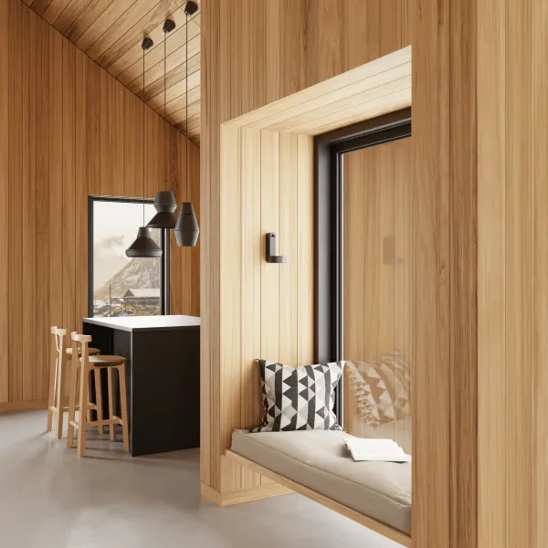 Moderner Wohnraum mit Holzvertäfelung, Sitznische mit grauem Polster und geometrischem Kissen, Blick auf schwarze Kücheninsel mit Barhockern und Pendelleuchten