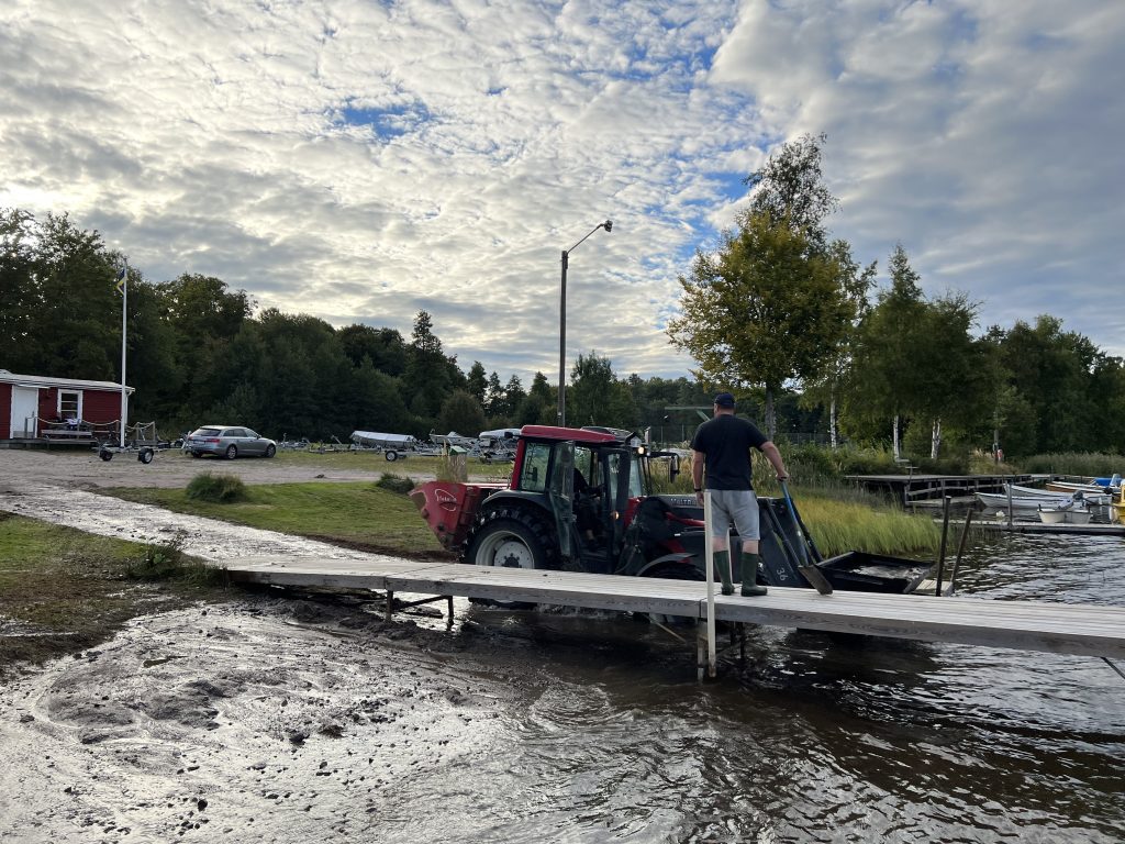 Bild på traktor med frontlastate. Erik och Joakim jobbar med att gräva ut vid iläggningsrampen