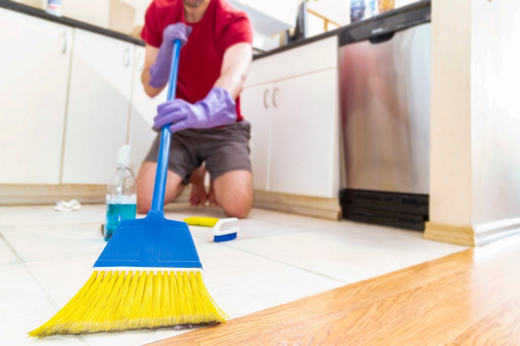 Person using broom on floor