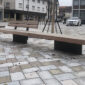Hopbyggd stilren parkbänk på ett torg