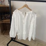 Romantische witte blouse met bloemenstructuur en elegante pofmouwen.
