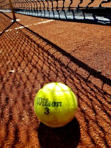 Ein Tennisball liegt am Tennisplatz vor dem Netz