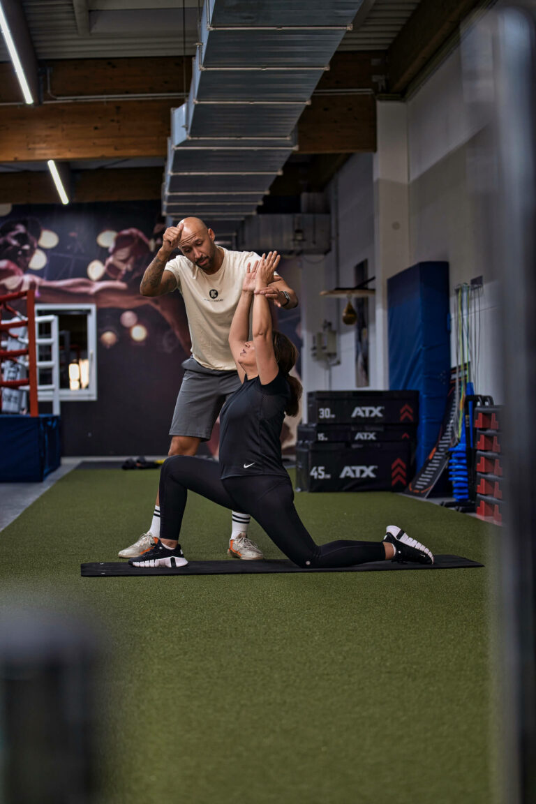 Ein Fitnesscoach gibt einer Teilnehmerin Anweisungen