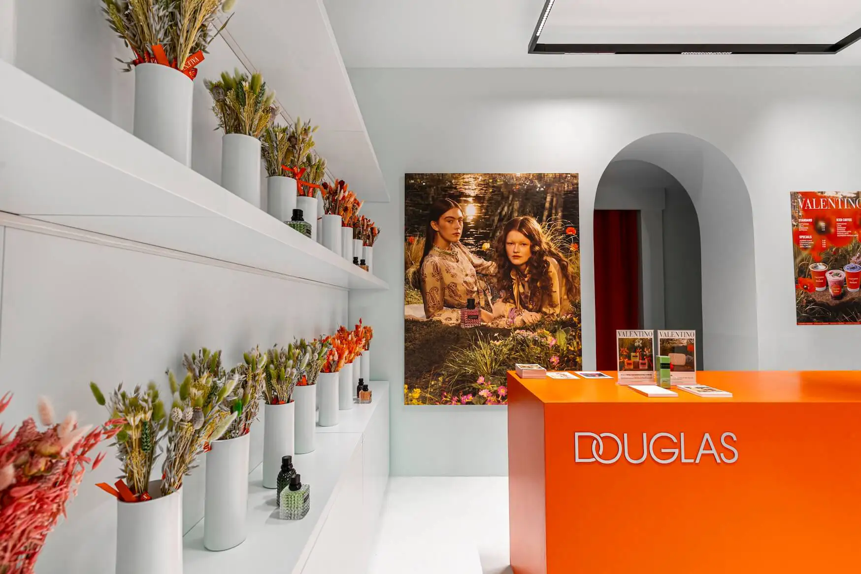 Moderner Empfang mit orangefarbener Theke und Branding.