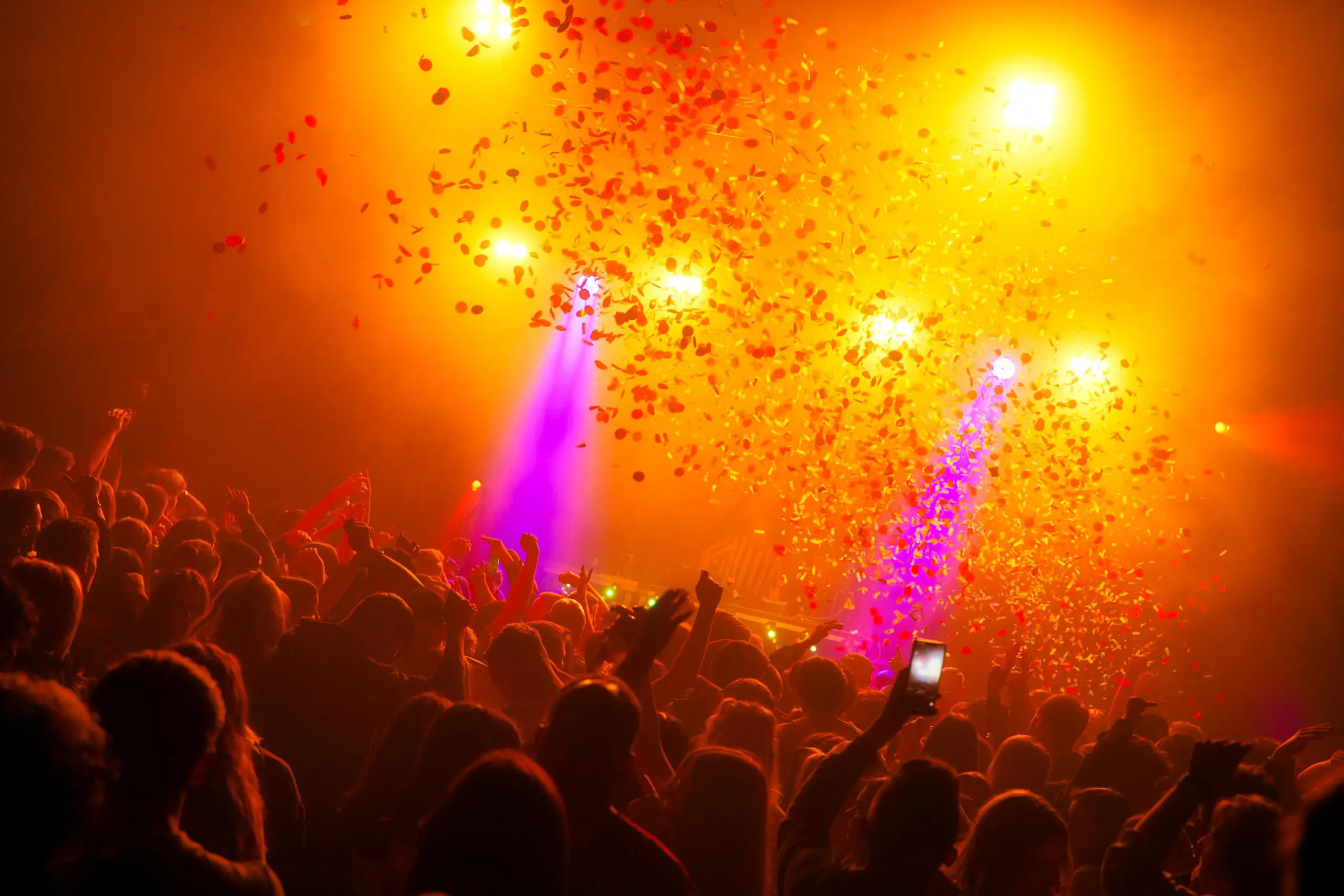 Partyaufnahme mit Konfetti und orangenem Licht