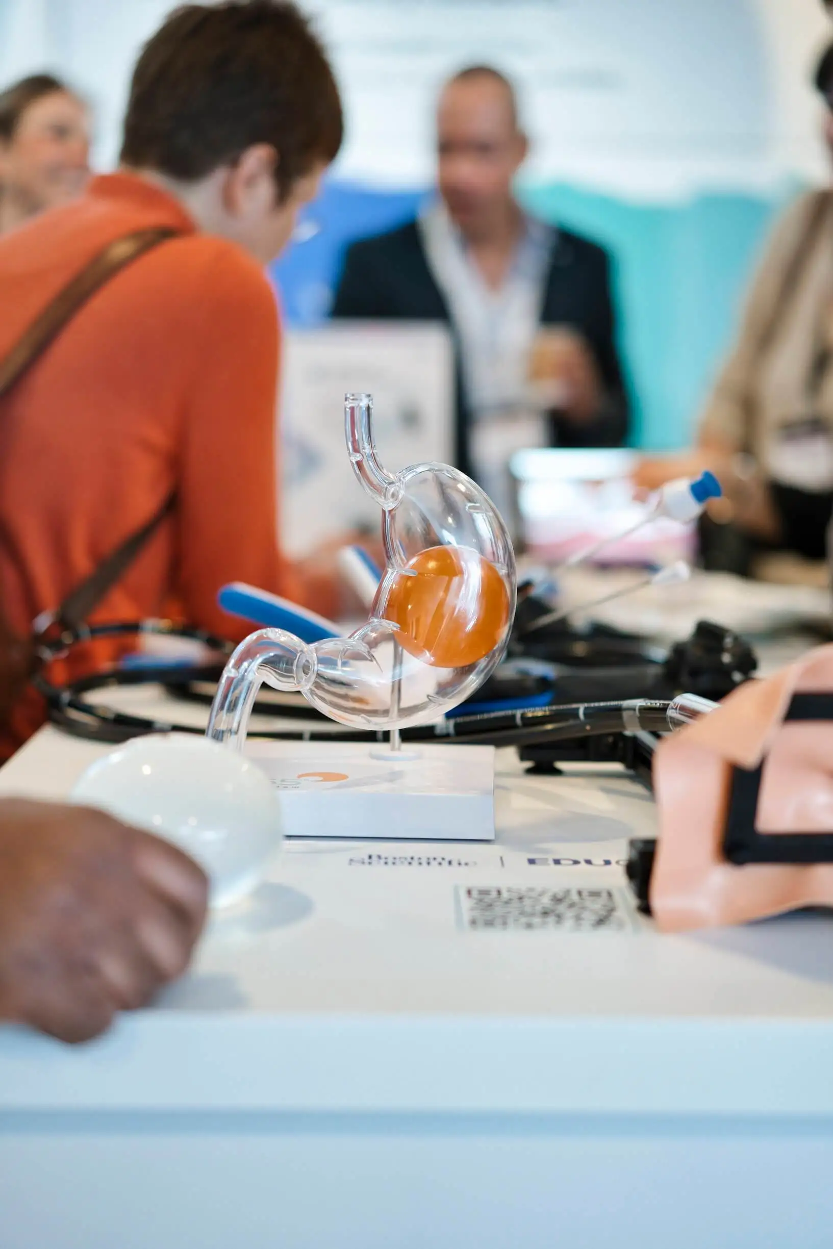 Event Fotograf hält Austausch und Beratung auf Firmenmesse fest. Nahaufnahme eines Organs aus Plastik