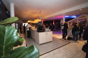 Übersicht der Eventlocation Sturmfreie Bude Düsseldorf mit zentraler Bar, Stehtischen und Gästen in farbenfroher Lichtstimmung – Eventfotografie von Schwarzekreide Media, Eventfotografin Düsseldorf.