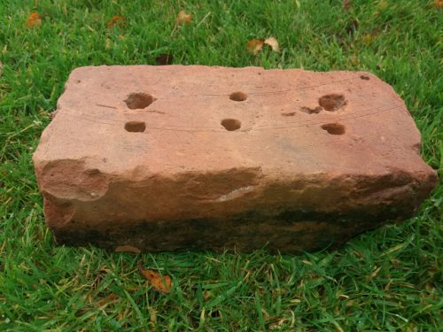 Cored brick displaying lifting tool marks.