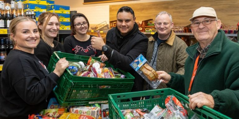 team with donated food in supermarket