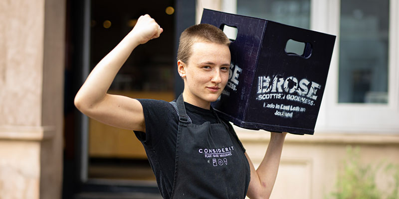 Person carrying Brose Oats crate