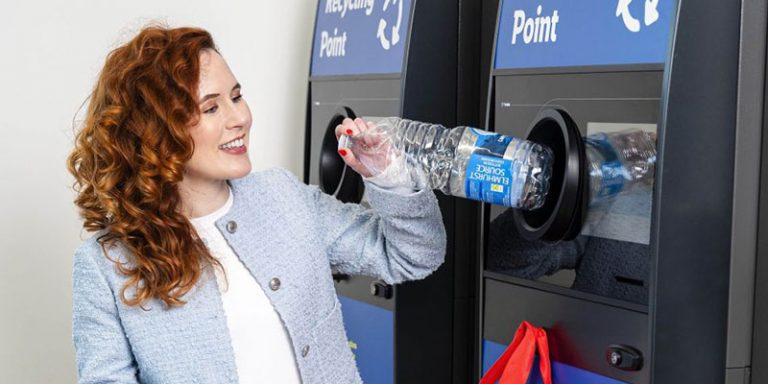 Person putting bottle into reverse vending machine