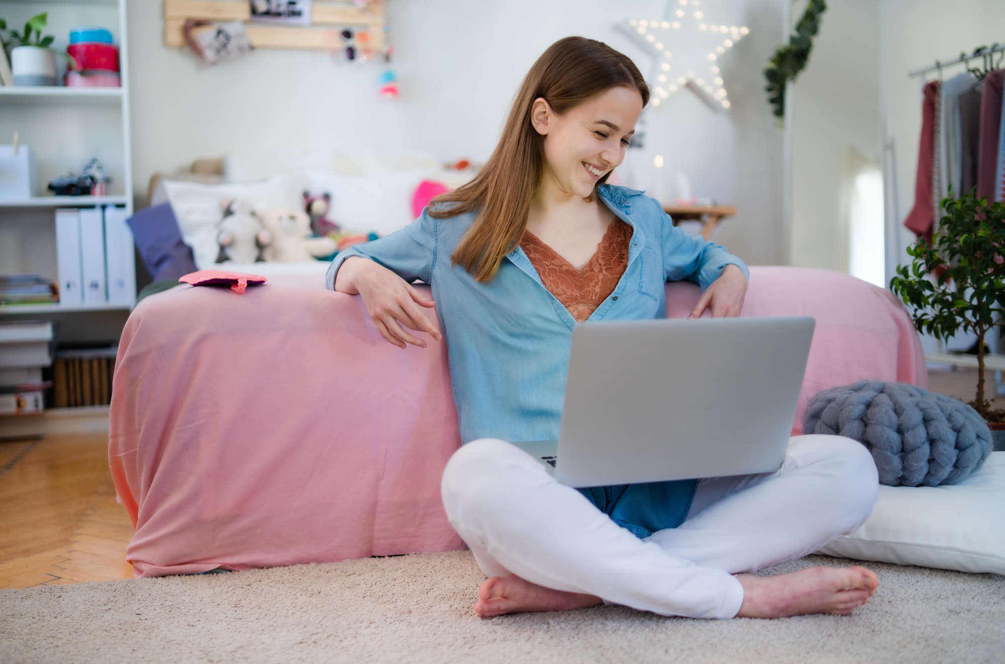 Beautiful happy young girl with laptop sitting and smiling, online dating concept