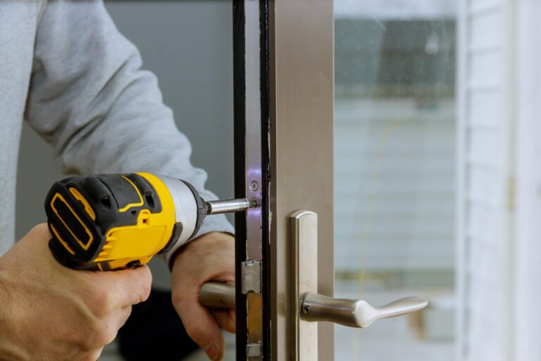 Locksmith in installing new house door lock hand holds the screwdriver