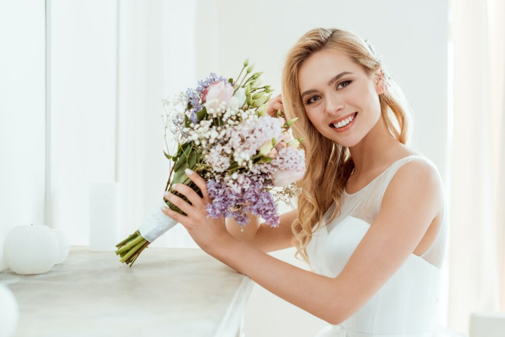 smiling young bride in wedding dress with wedding bouquet